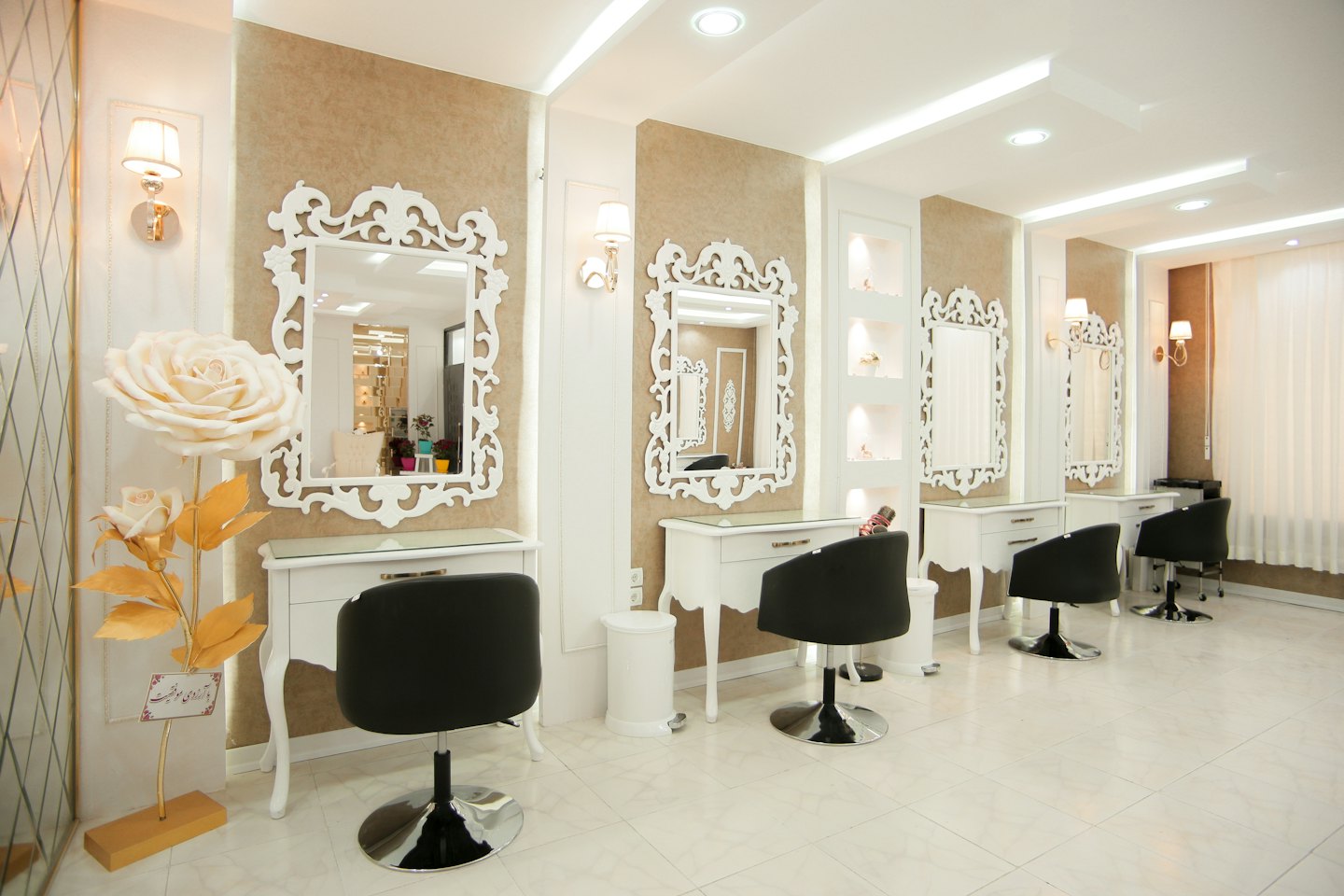 Modern beauty salon interior with styling stations and decorative rose sculpture.
